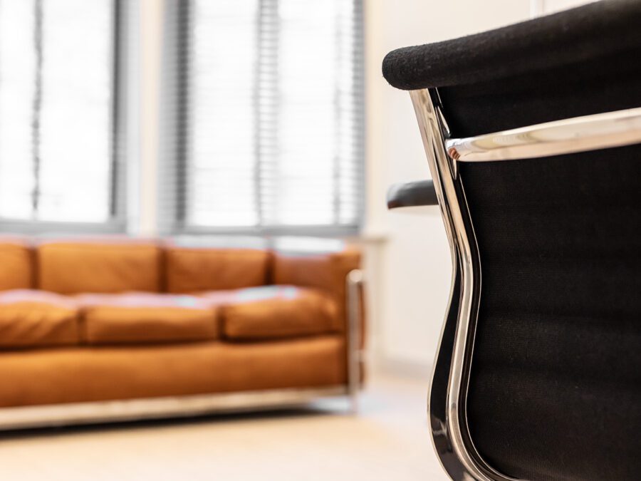 Braunes Sofa mit schwarzem Konferenzstuhl