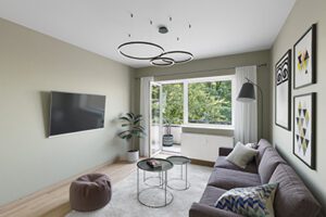 Virtual Staging eines Wohnzimmers mit grüner Wandfarbe und grauer Couch in Hamburg-Barmbek