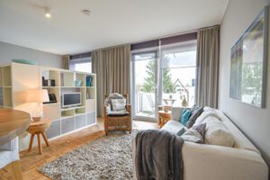 Möbliertes Wohnzimmer mit beiger Couch und grauem Teppich mit Balkon in Hamburg-Lokstedt