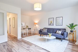 Home Staging Wohnzimmer mit hellem Boden und blauer Couch in Reihenhaus in Neu Wulmstorf