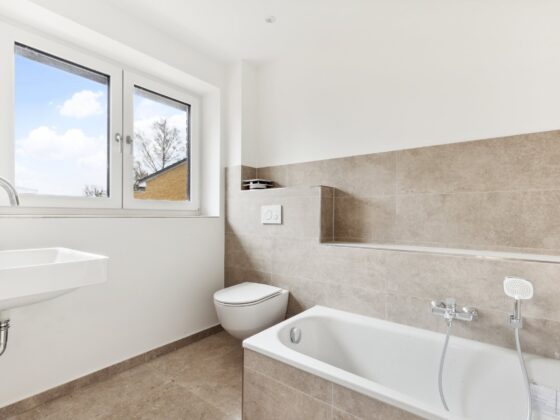 Modernes Badezimmer mit Badewanne und grauen Fliesen in Neubau Doppelhaushälfte in Hamburg-Volksdorf