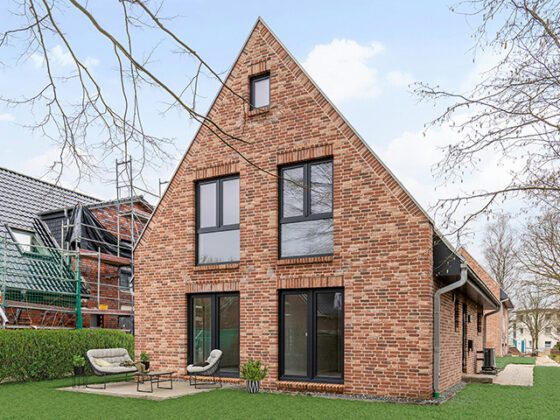 Außenansicht Neubau Rotklinker Einfamilienhaus mit Terrasse und Rasen in Hamburg-Volksdorf
